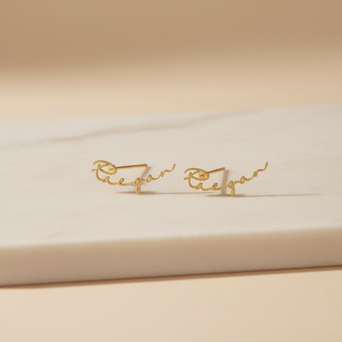 Boucles d'oreille personnalisées posées sur fond crème